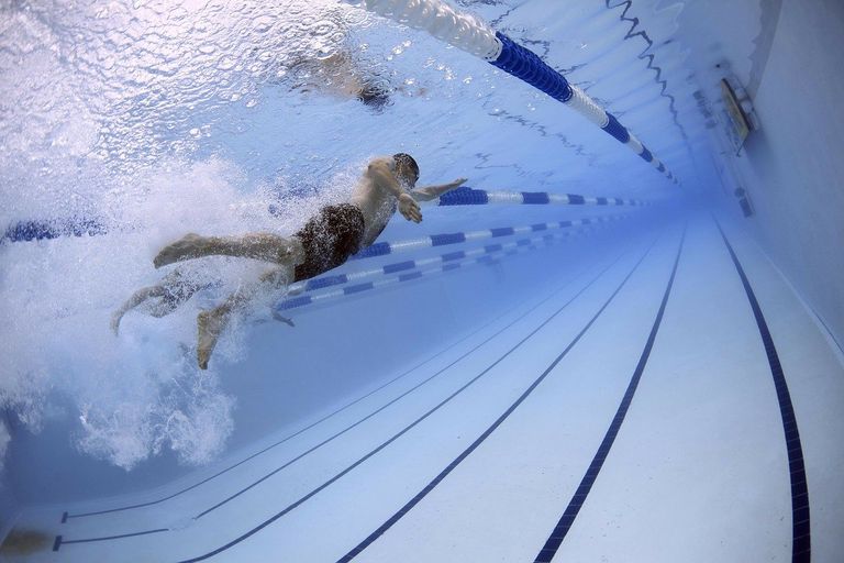 Ein Schwimmer krault aus einer Unterwasserperspektive in einem Schwimmbecken