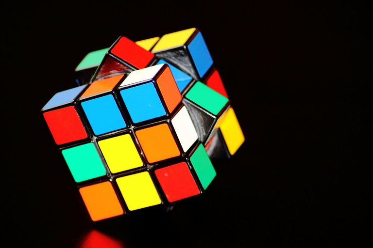 Ein Rubic Cube vor schwarzem Hintergrund mit einer halb gedrehten Fläche
