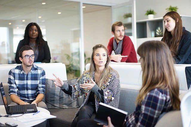 Studenten:innen sitzen in einer Gruppe zusammen und diskutieren